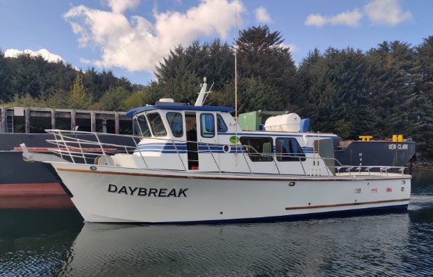 DAYBREAK – Full Day Sport Fishing Charter Image 1 a boat is docked next to a body of water